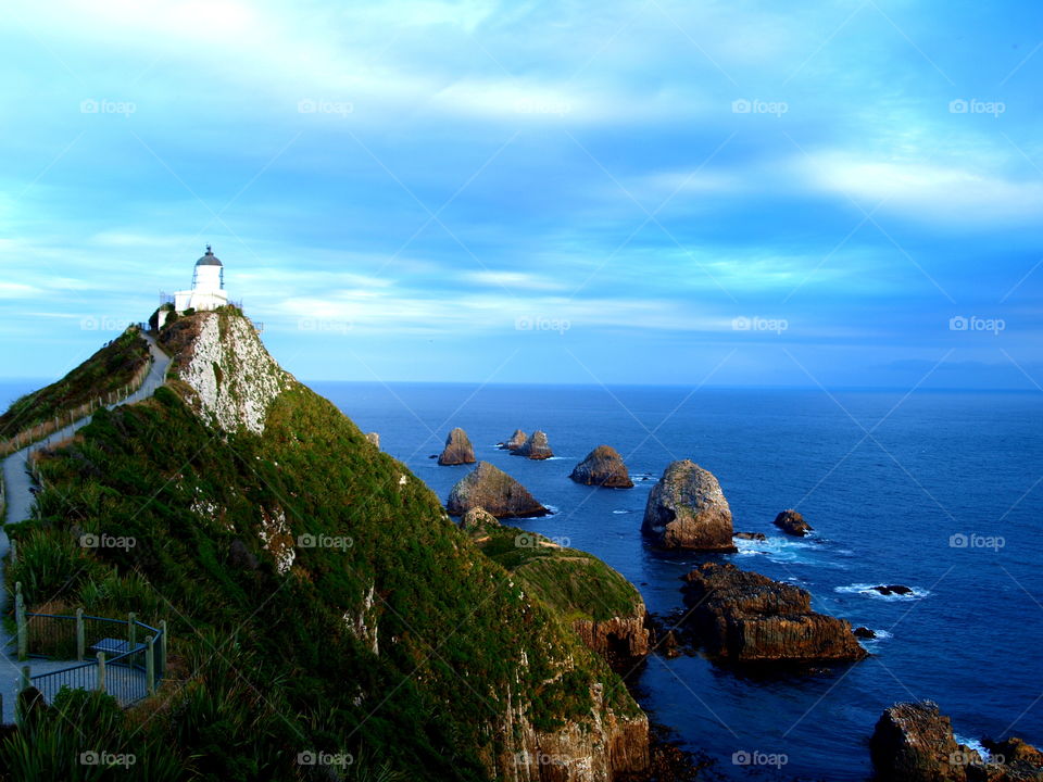 clouds over the Nugget Point lighthouse in new Zealand