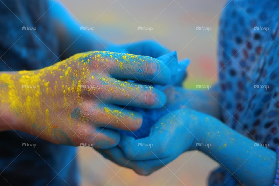 Hands with yellow and blue powder 