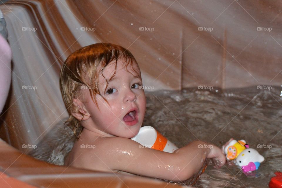 Baby bath time.  Two year old toddler girl has a jacuzzi bath at the hotel 