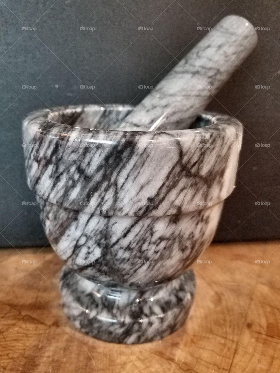 Mortar and Pestle, gray striated marble, side view.