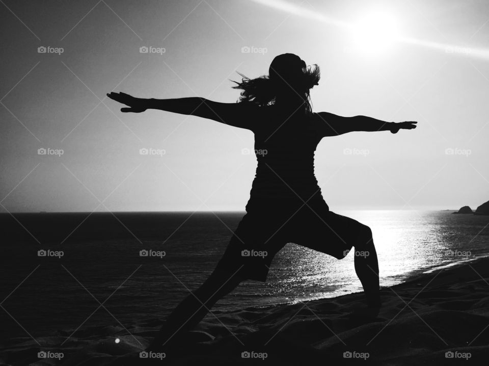 Woman doing a yoga pose on the beach
