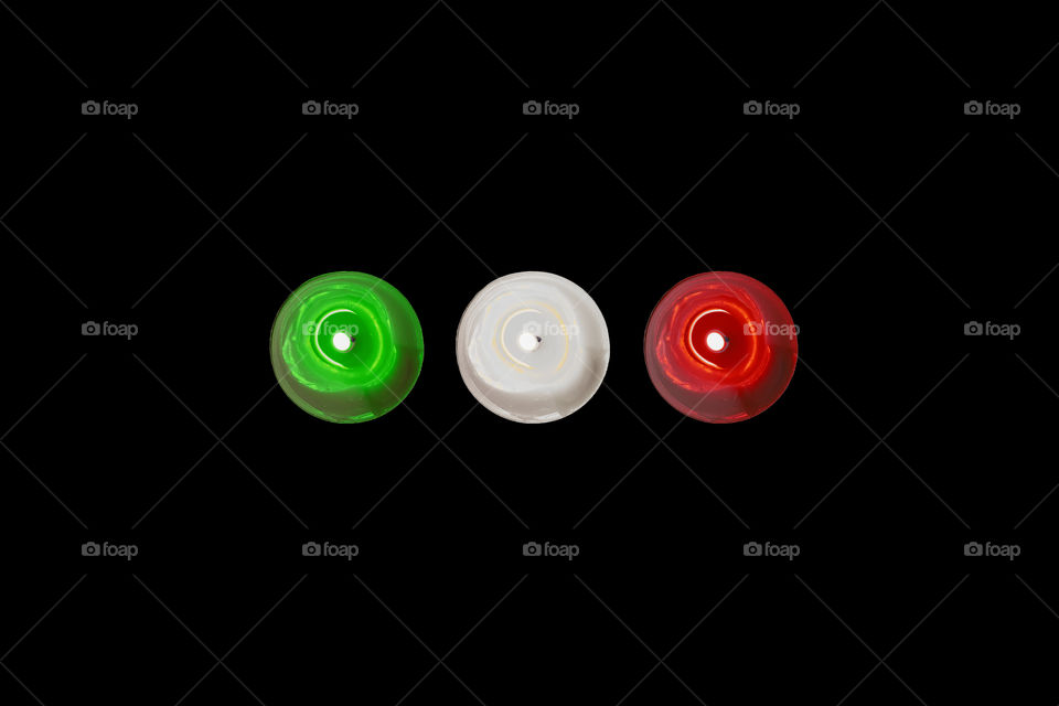 Three burning candles in a dark room, Italian colors. A hope for my Italy affected by the Coronavirus