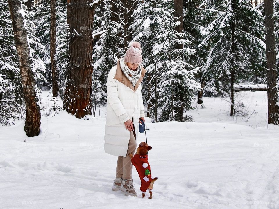 woman with dog in winter forest