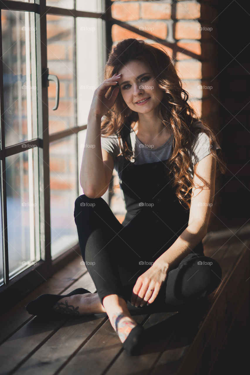 Portrait of young beautiful woman near window