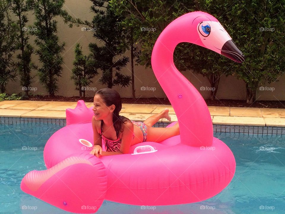 Child in pink flamingo inner tube