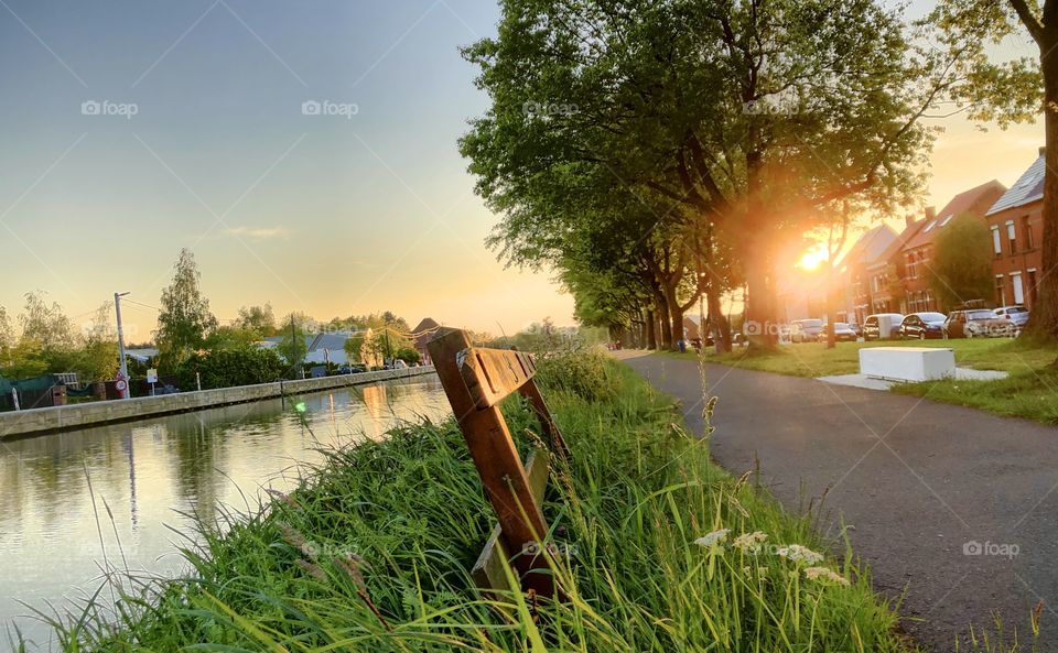 Sunset or sunrise taken from the Grassy riverside showing a small wooden fence and trees