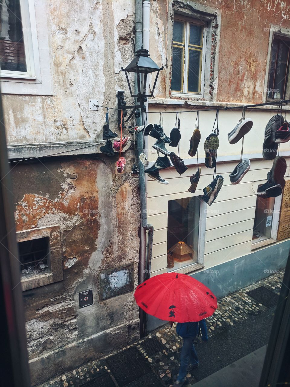 A man with an umbrella walks through the city center.