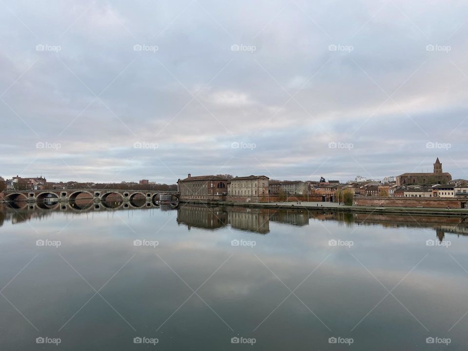 Bridge and buildings of Toulouse reflecting in the Garonne river