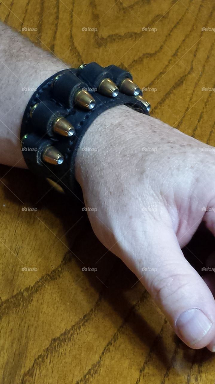 A handmade men's leather bracelet with bullets.