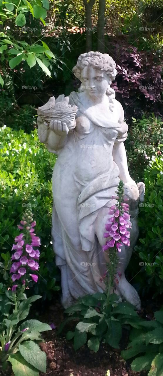 Woman's sculpture holding bird nest in the park