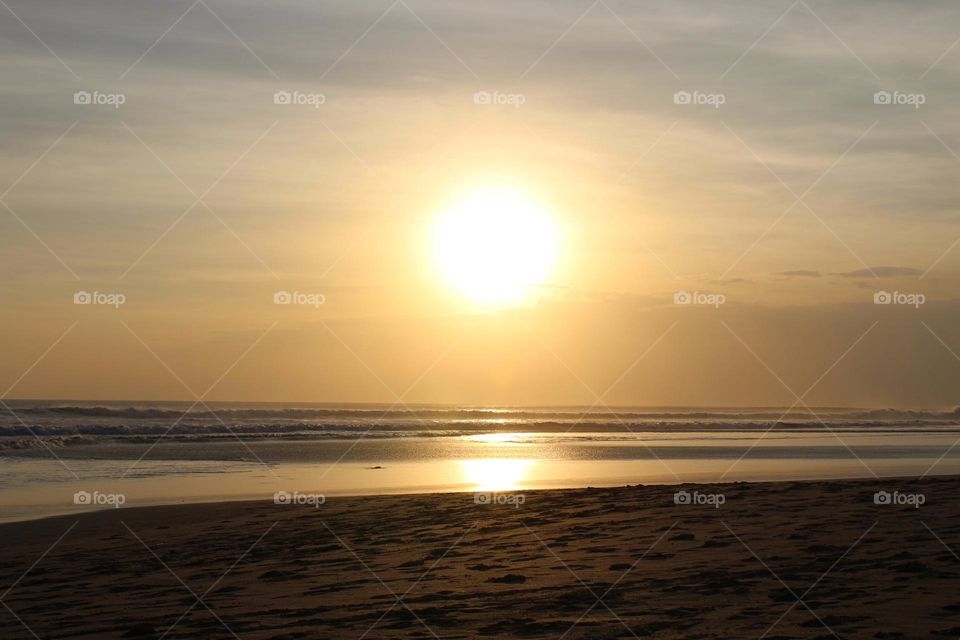 Panoramic sunset and coastline views during leisure walks in Seminyak area of Bali island. 