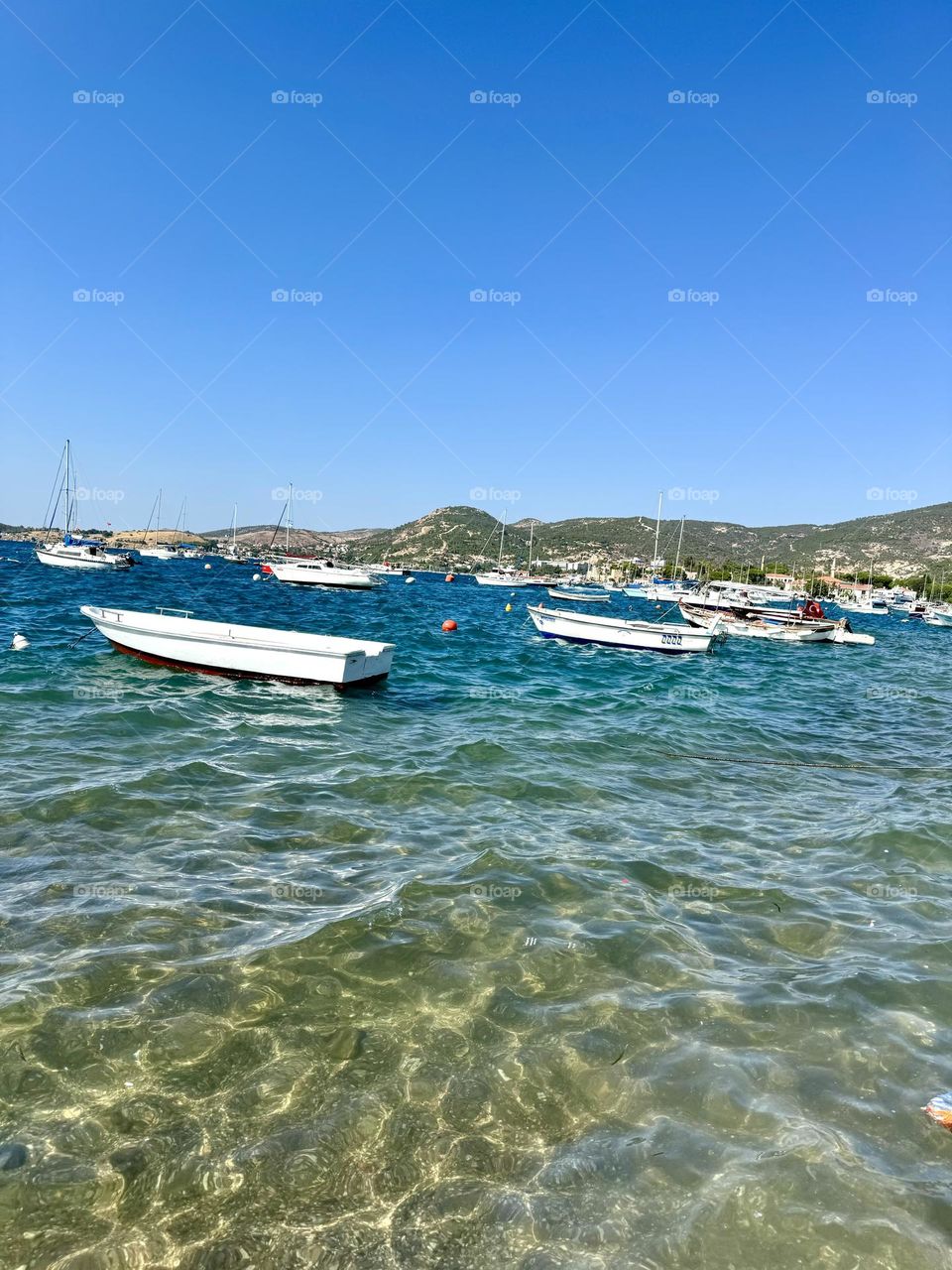 The sea with clear water, mountains and many boats
