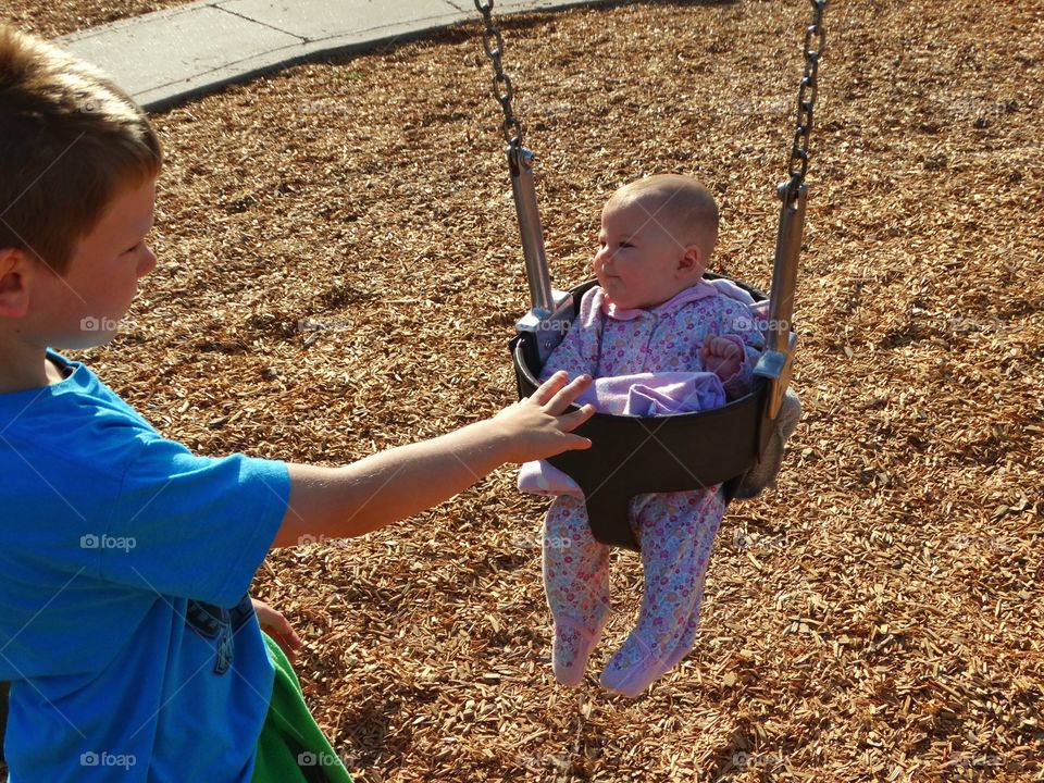 Pushing A Baby On A Swingset