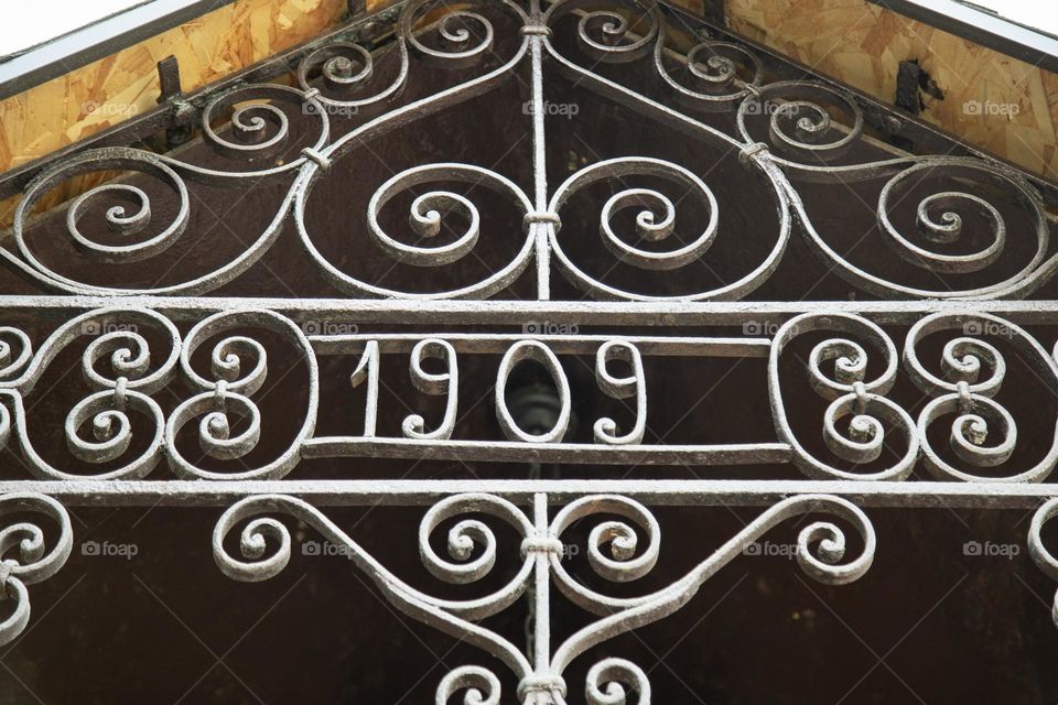Close-up of an old iron design with inscription 1909 year.
