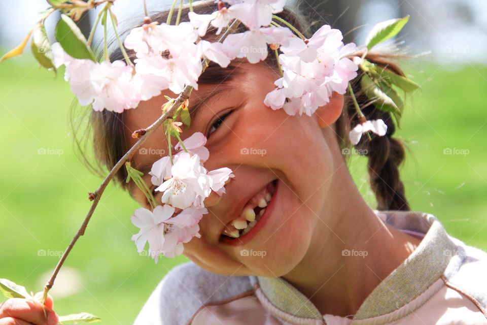 Happy cute girl with a cherry blossom