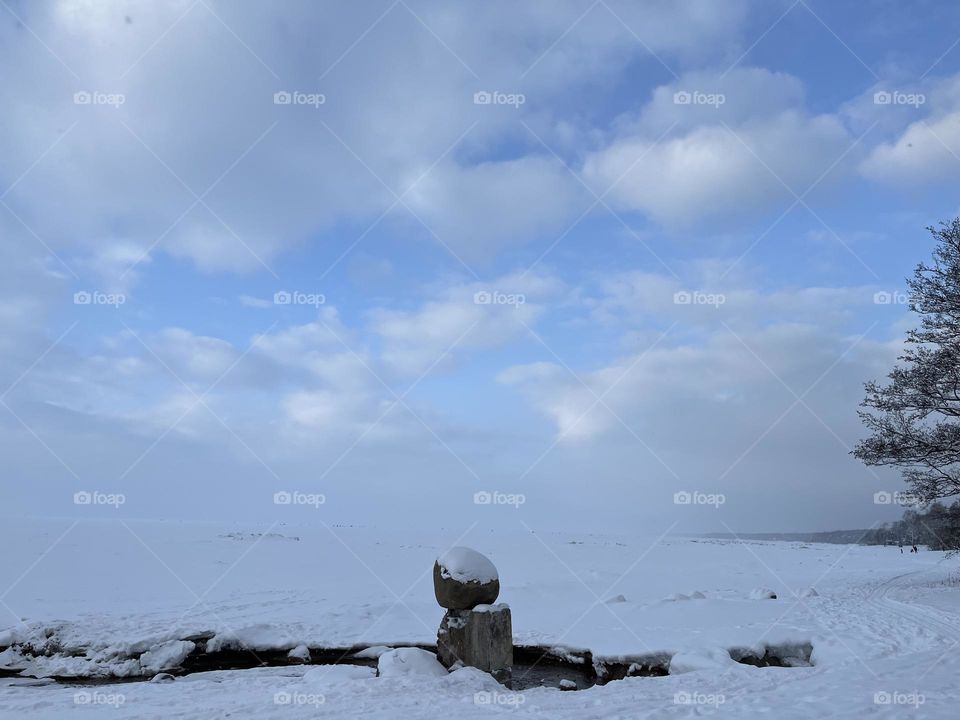 Snow coast stones and sky