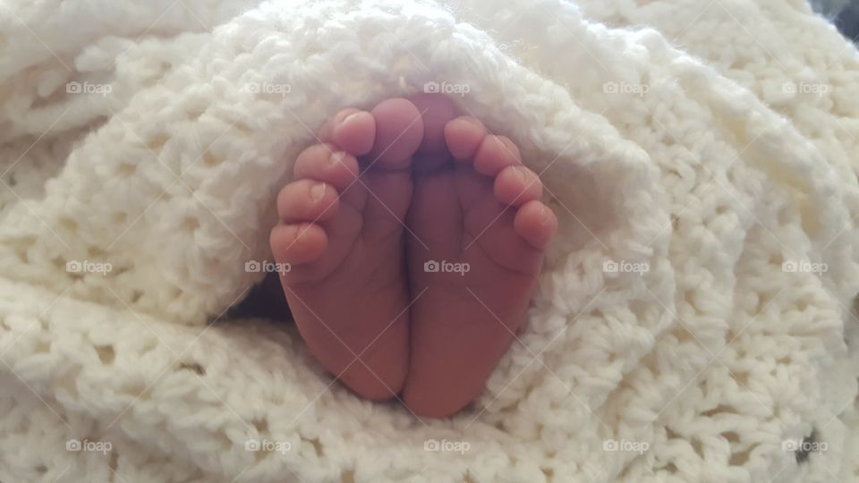 I captured my newborn's tiny, delicate feet. He was cozy and warm in a handmade blanket.