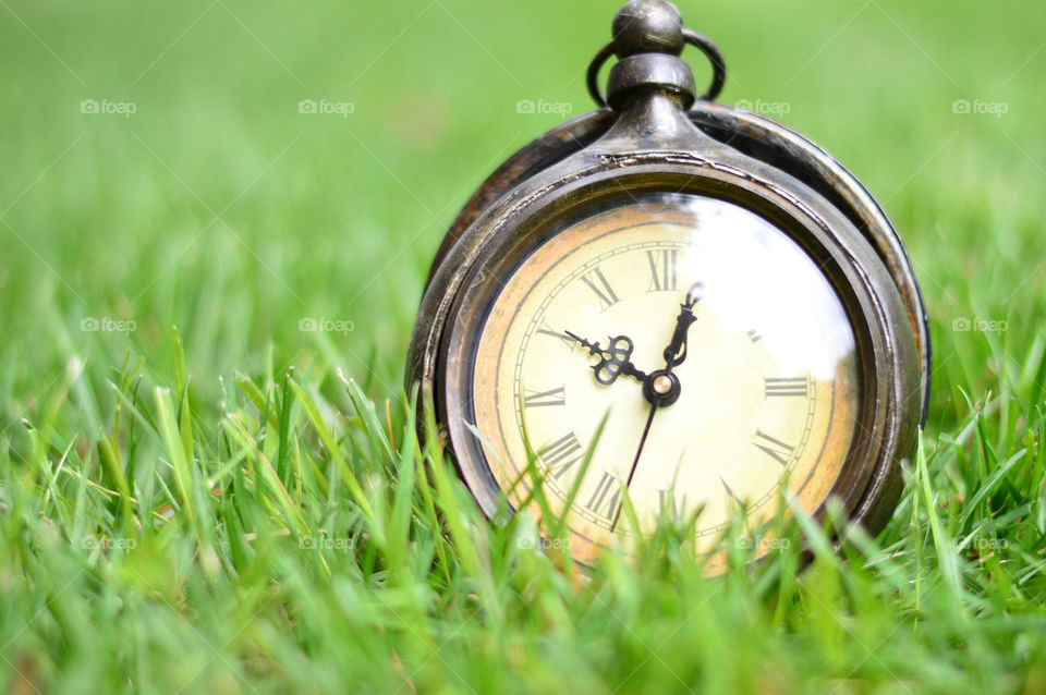 clock outside on the grass