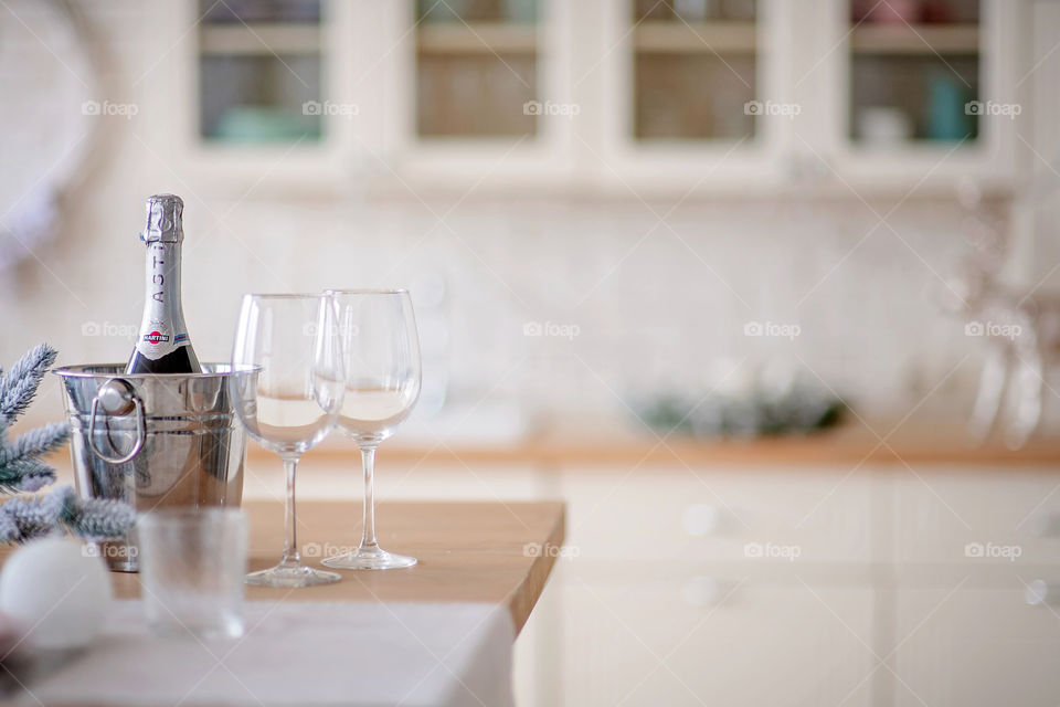 Festive winter cozy kitchen interior with garlands, decorations and gifts.  Christmas dinner at the decorated table.