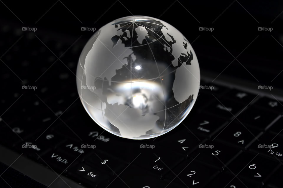 Close-up of a crystal globe on computer keyboard
