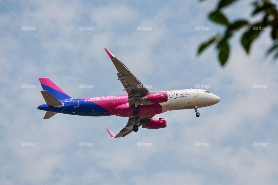 An airplane (Airbus A320) in the blue sky preparing to land at an airport in Sofia, Bulgaria, Europe