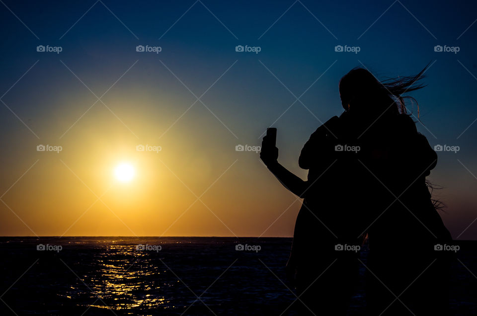 Group selfie on the beach at sunset