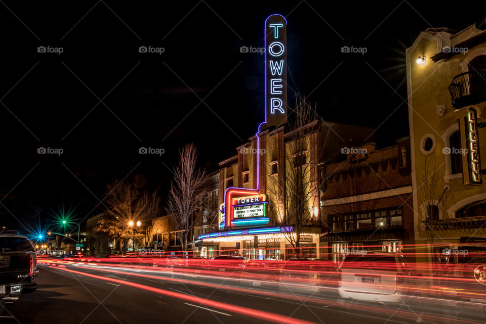 Cars streaming lights down the city street in front of the Tower Theatre in Bend Oregon at night 