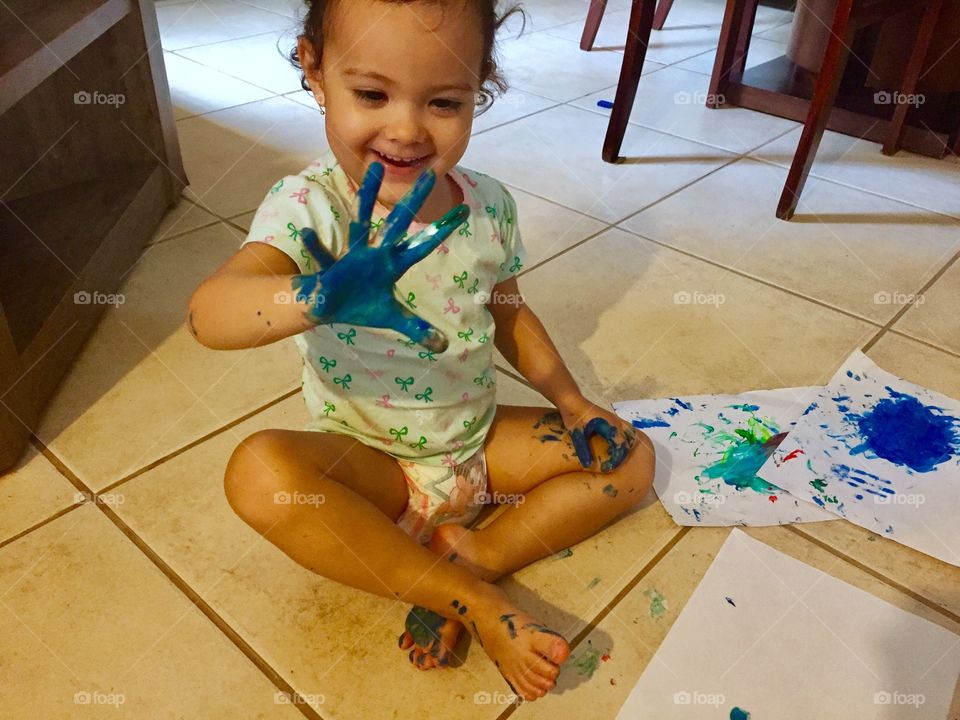 Painted hands of smiling baby girl