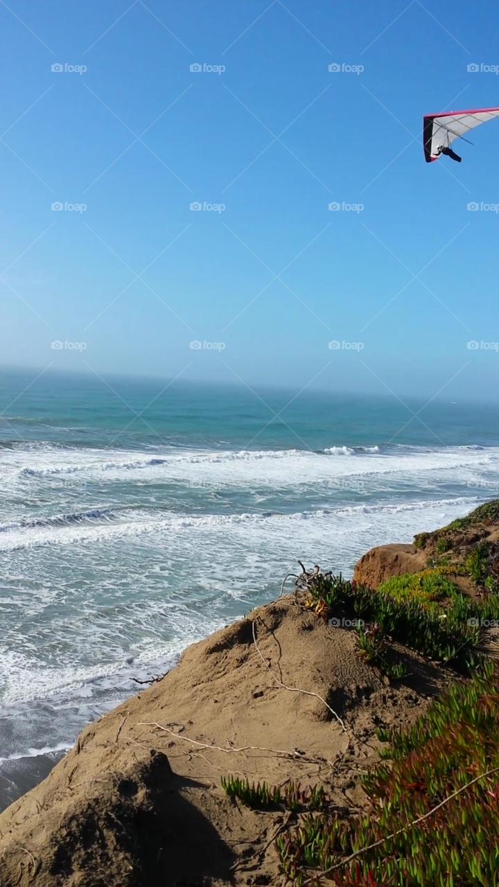 hang gliding by ocean