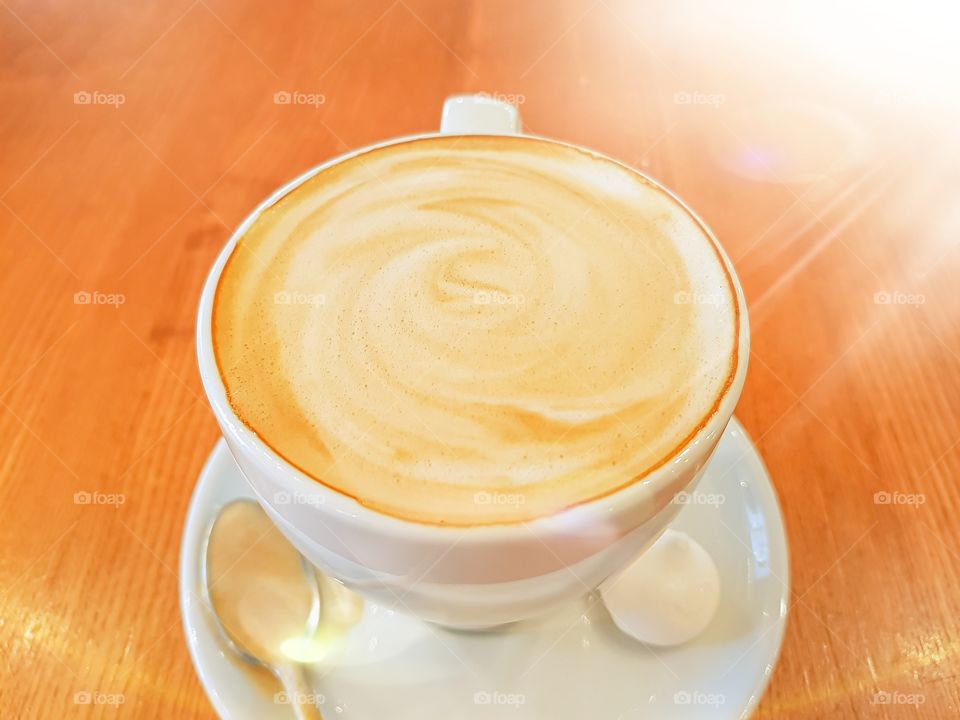 Cup with cappuccino in the morning lights.