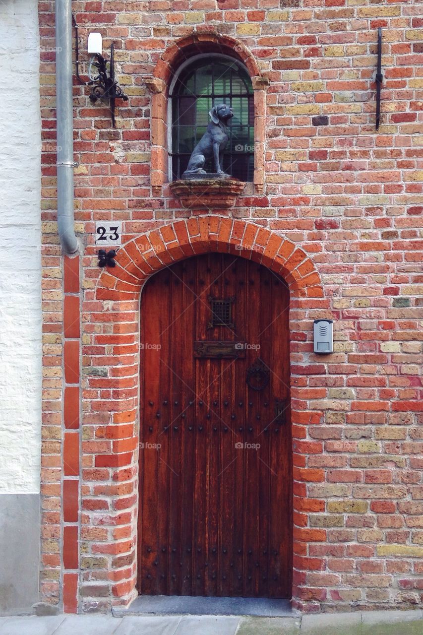 Wooden door with statue of dog in Brugge 