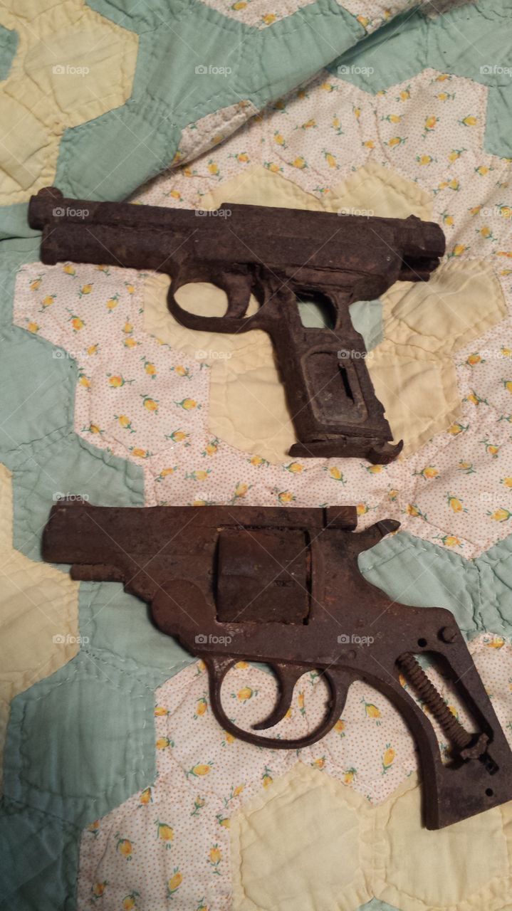 Vintage rfamily heirloom firearms displayed on quilted surfaceustic