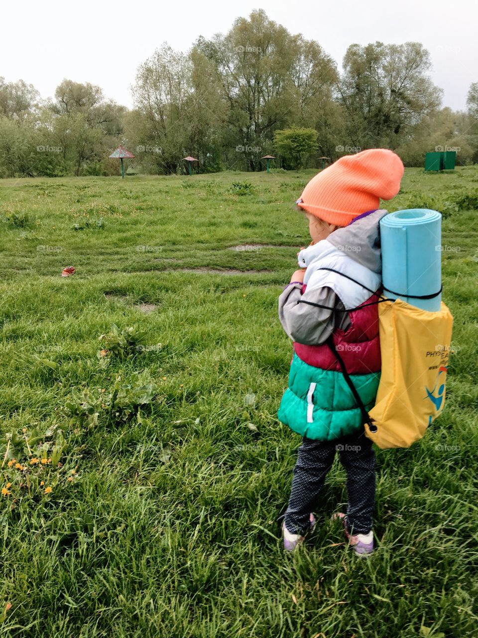 Little girl enjoying nature with her serious hiking backpack