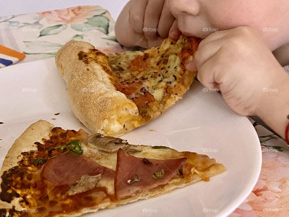 Little boy eats delicious pizza 