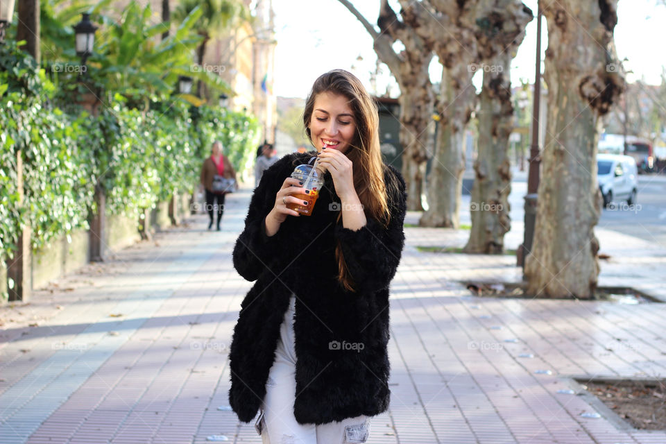 Woman drinking with straw on street