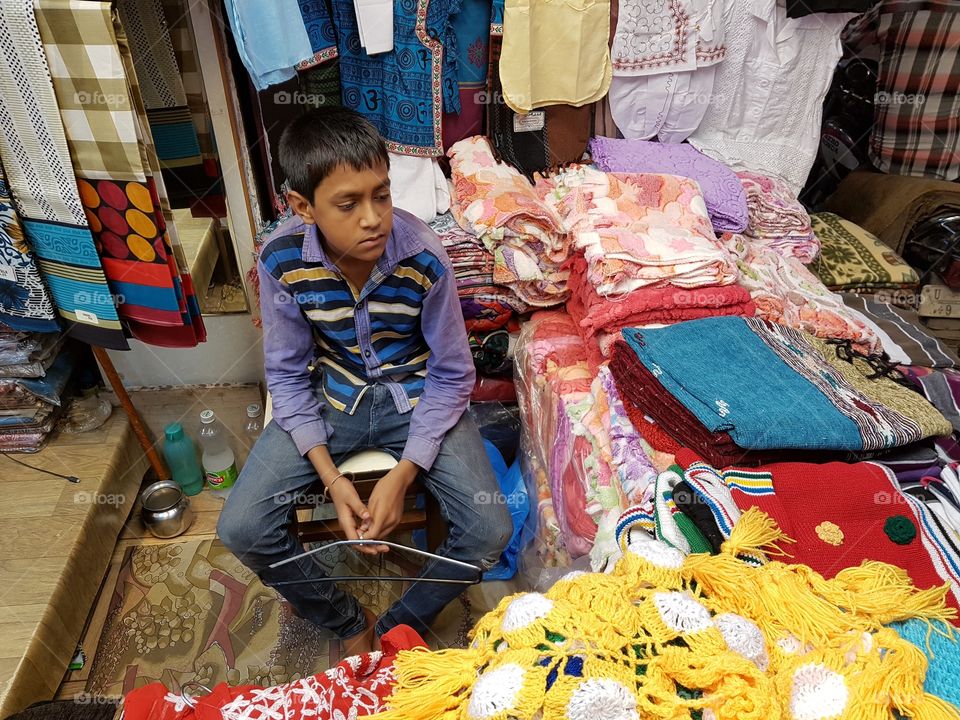 a boy selling indian traditional cloths