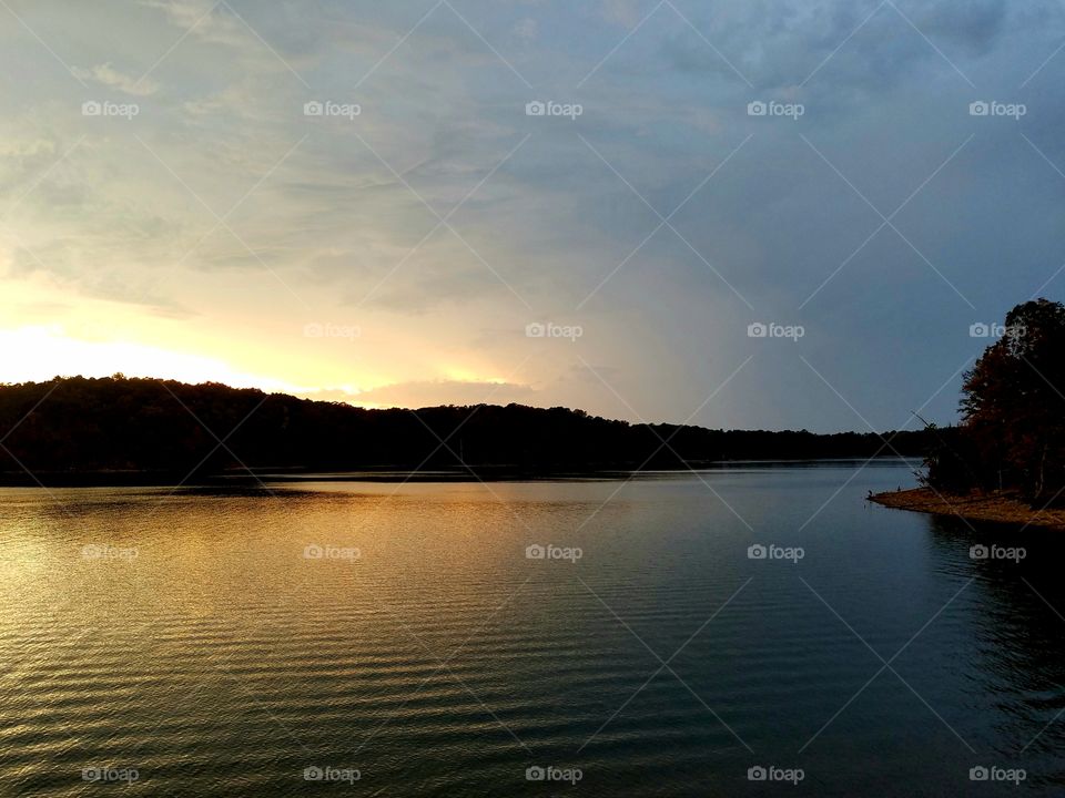 sun setting over lake