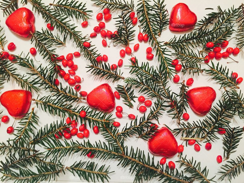 Overhead view of chocolate hearts with christmas tree branches