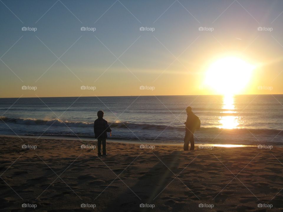 Super dad and son enjoying a winter sunset. Both love the beach, be it summer or winter.
