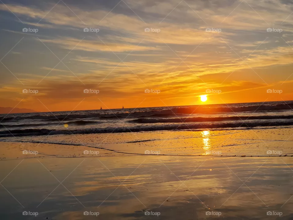 Sailboats on the horizon during a beautiful sunset