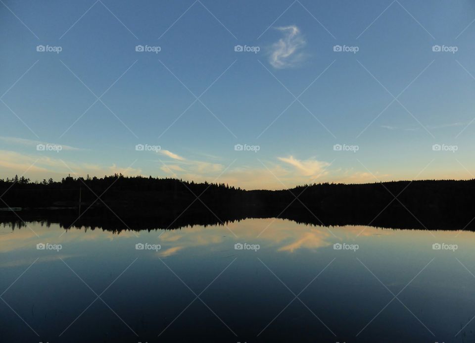 Silhouette of mountain reflected on lake