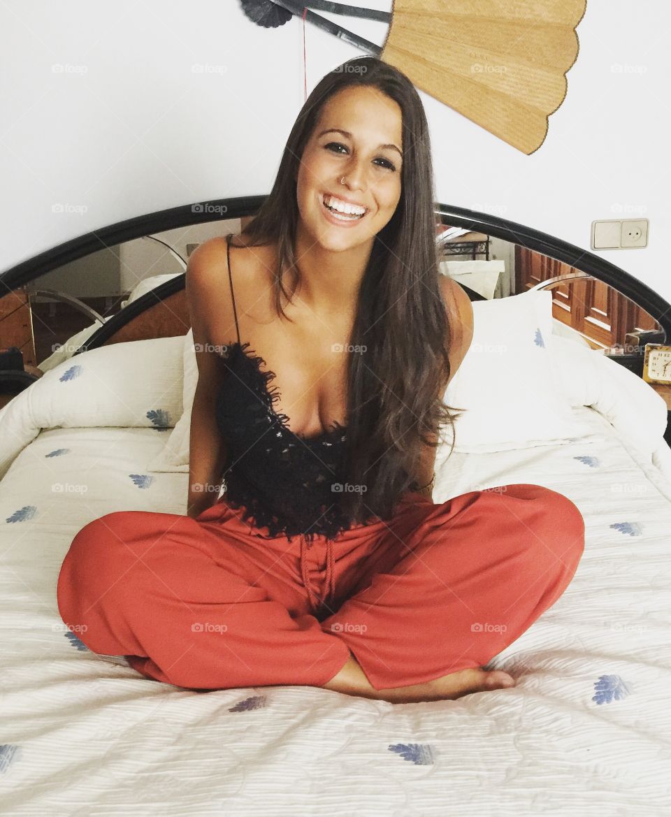 Attractive women sitting on bed and laughing