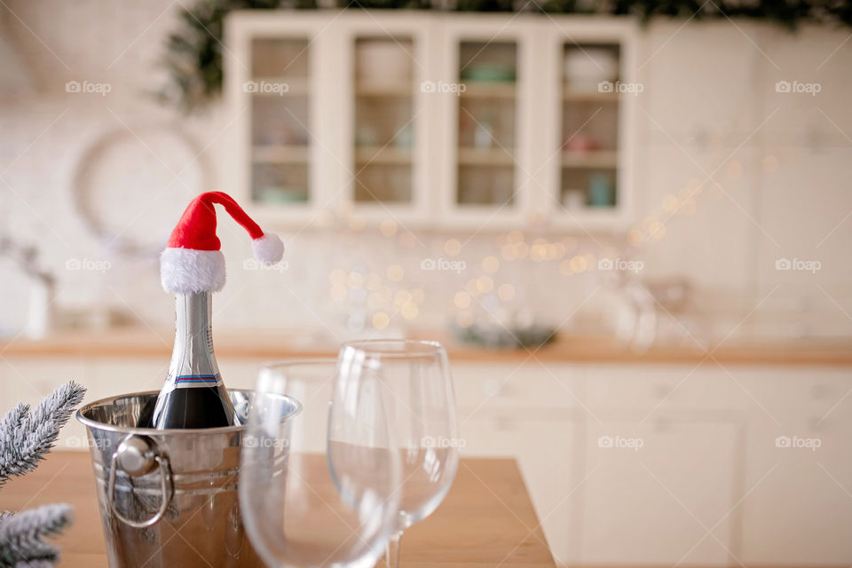 Festive winter cozy kitchen interior with garlands, decorations and gifts.  Christmas dinner at the decorated table.