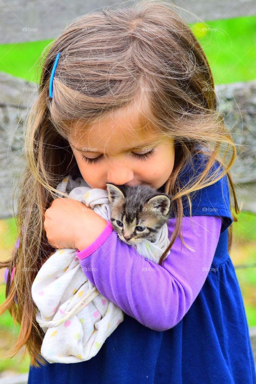 little girl cuddling a kitten
