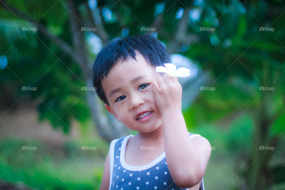 Smiling asian boy with flower