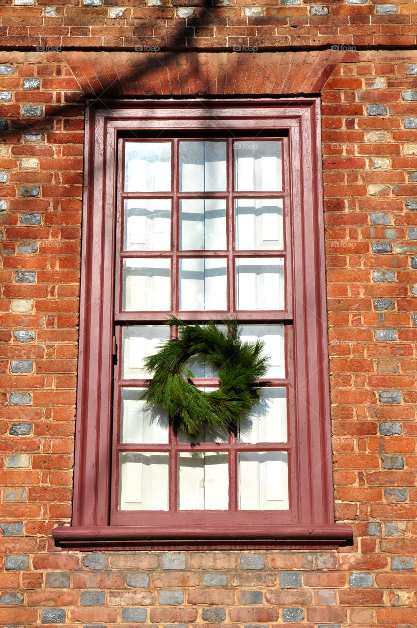 A beautiful vintage window decorated for Christmas in historic Williamsburg Virginia.