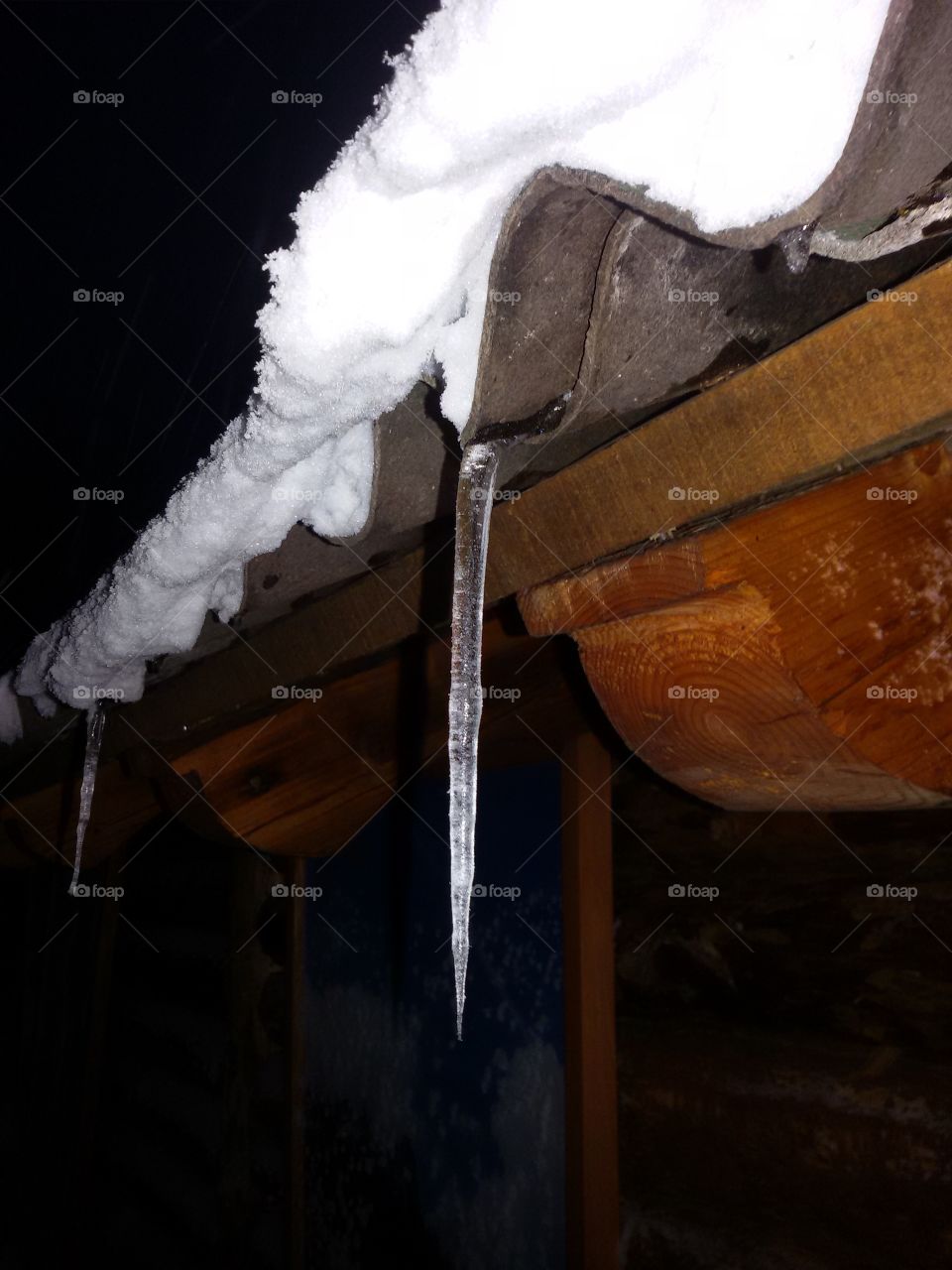 Icicle on a snowy roof