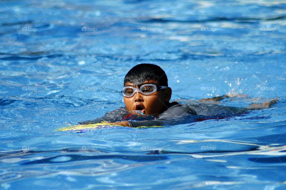 young kid swimming in a swimming pool