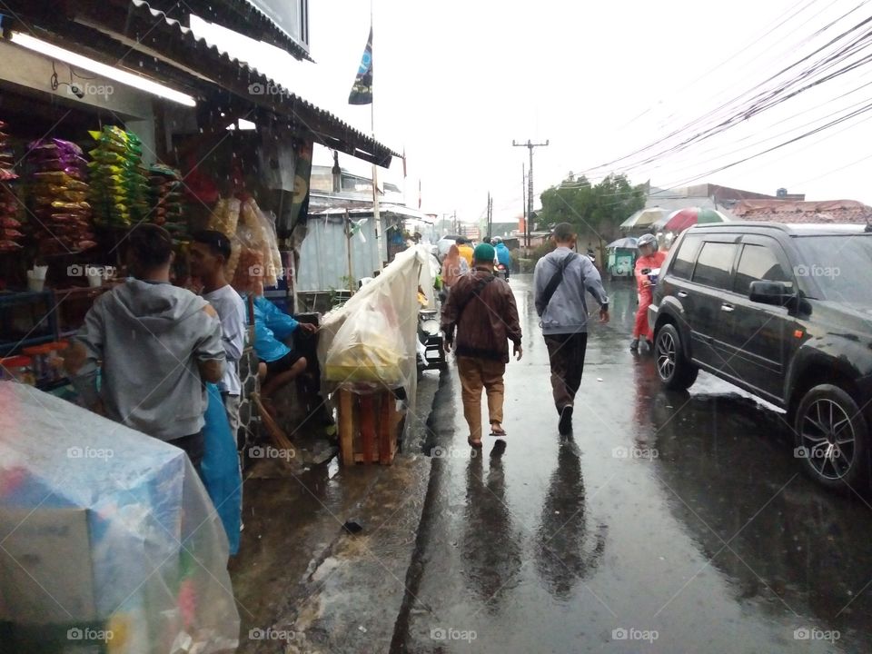 two man walking on street fastly for avoid rain