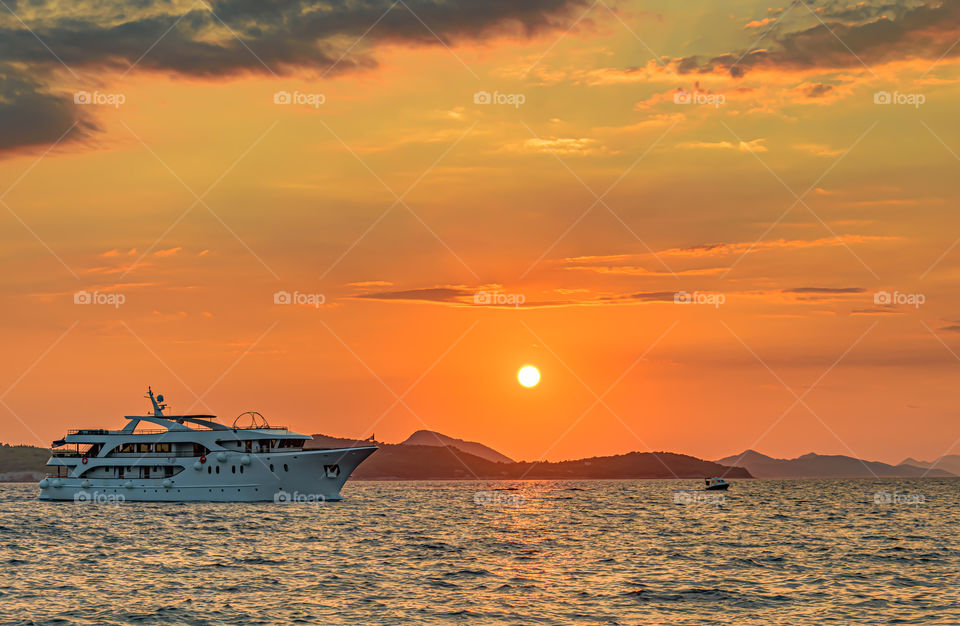 Ship sailing at sunset